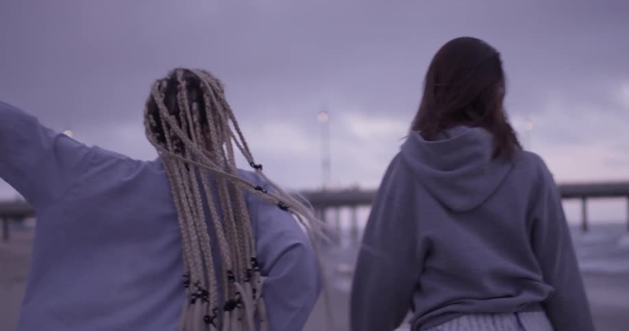 Two women dance and walk on the beach
