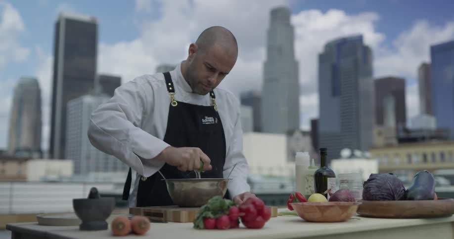 A man squeezing limes into a bowl