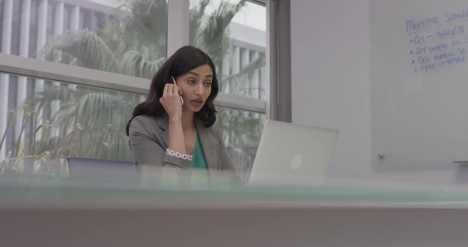 A woman is talking on the phone and writing things down