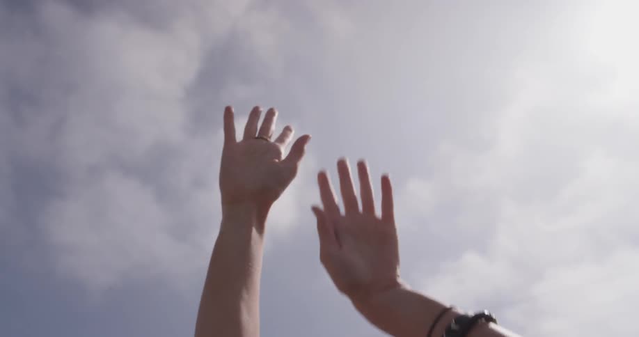 Women snaps her fingers to music and waves her hands around in the air of a hoodless car driving down the street on a bright sunny day