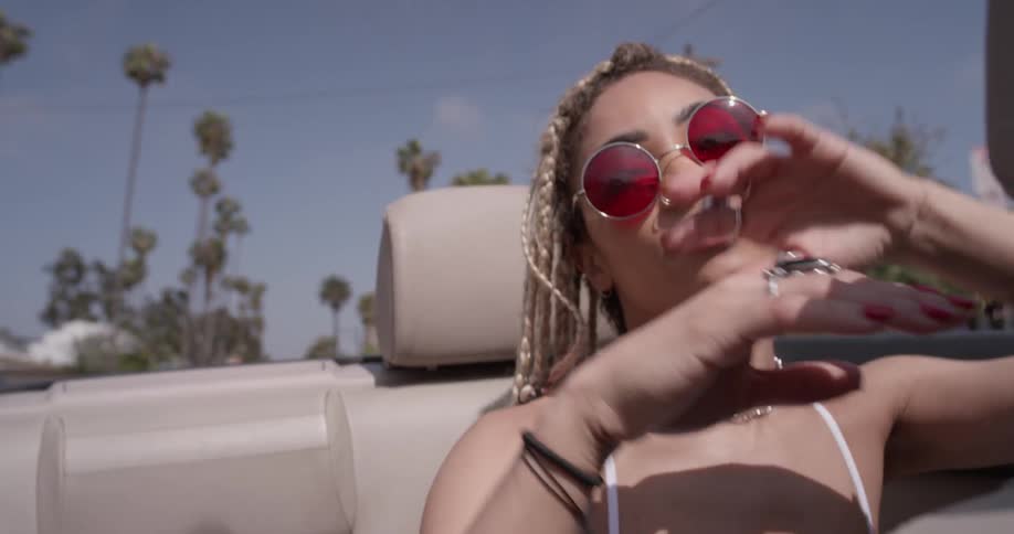 A woman is dancing in a car during daylight