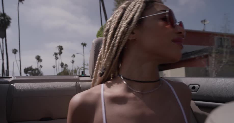 A woman dancing in the backseat of a car