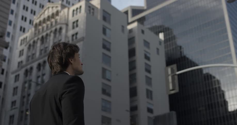 A man is looking at a building in the city
