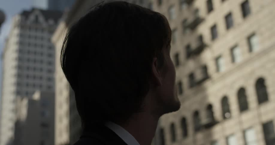 Man looks at skyscrapers from the ground