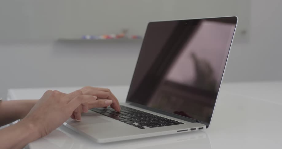 Person sits at a desk typing on a laptop