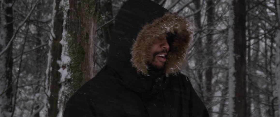 A man with a coat throwing a snowball