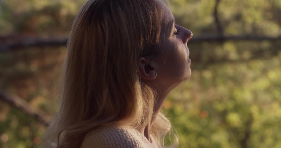 A woman sitting outside looking at trees