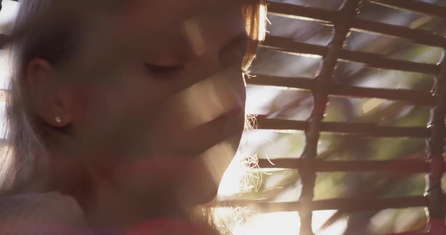 Woman sips steaming liquid out of a mug on a sunny day