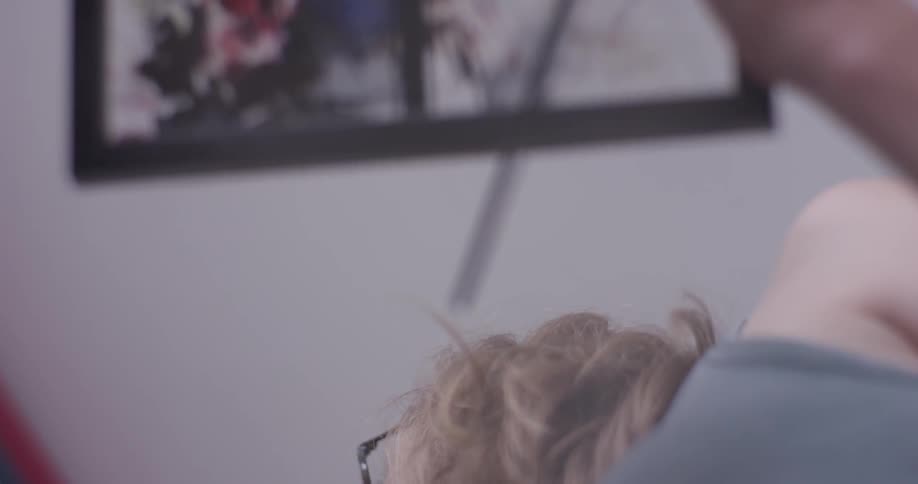 A woman sitting around looking at art in a studio