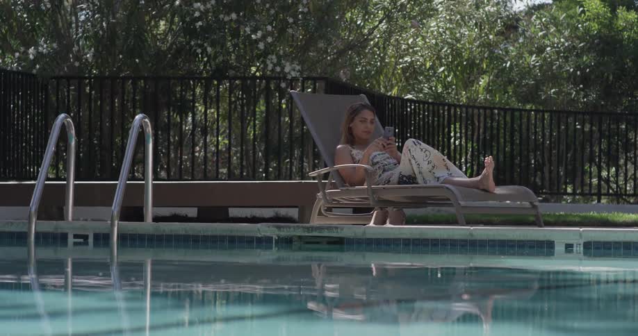 A woman laying out by a pool