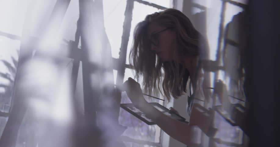 Woman paints in bright room