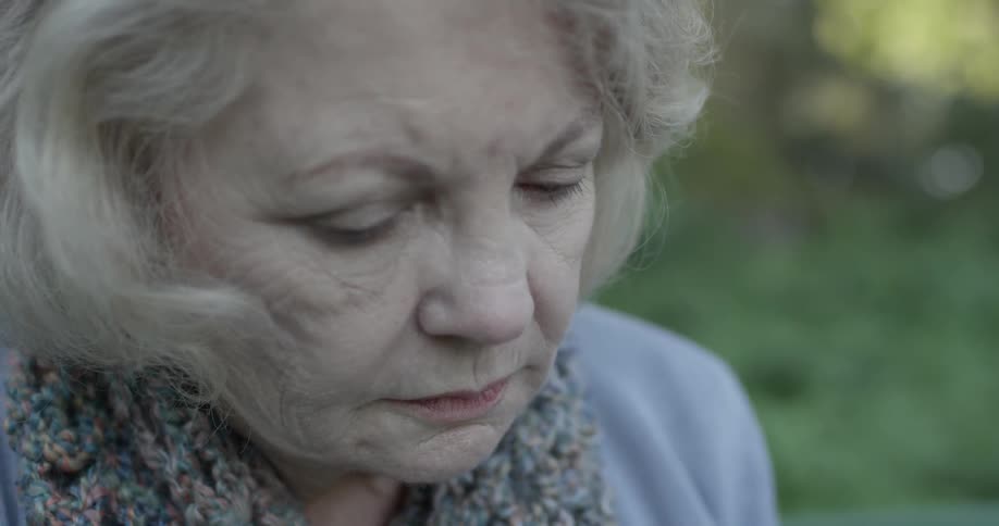A woman looking sad is staring towards the ground