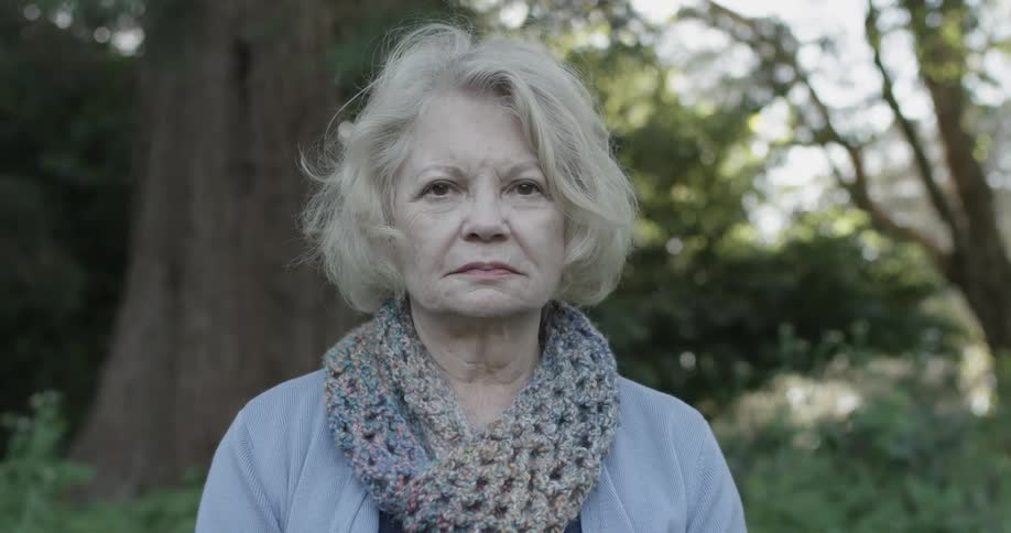 An older woman turns and faces the camera