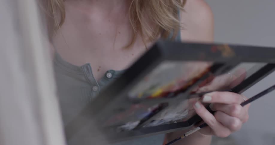 Woman holds easel and paints