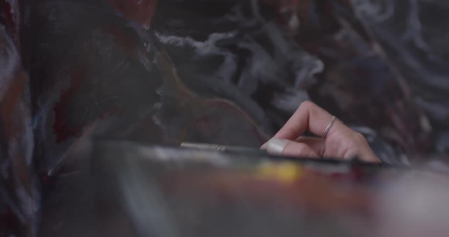 Woman using a paintbrush on a canvas