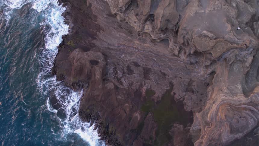 Waves bounce against the rocky cliffside