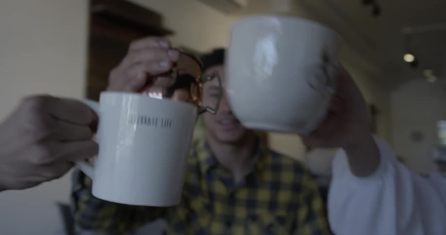 A group of people cheers mugs together