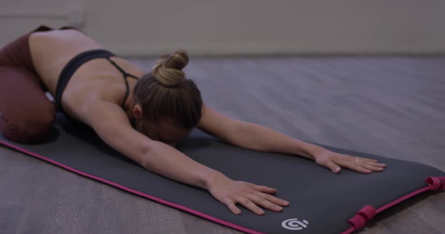 Woman doing yoga on a mat in a studio