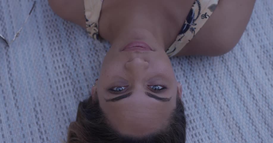 A woman is laying down on a blanket