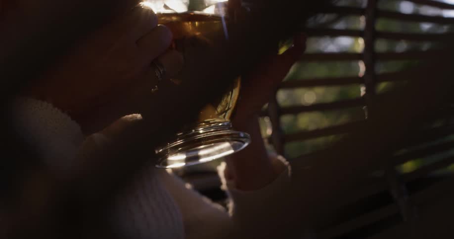 Woman sitting in a swinging chair outside sipping tea