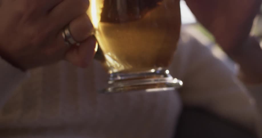 A woman takes a sip of tea that's in a clear mug