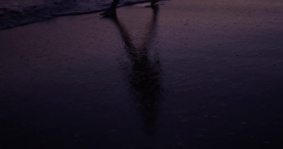 Person splashes through the water at night