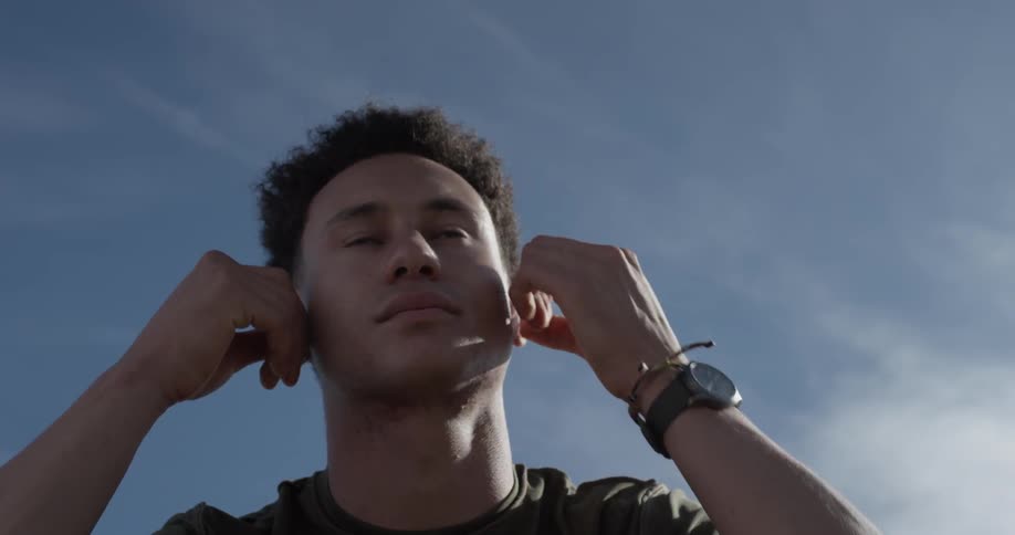 Man puts in earphones outdoors and walks away