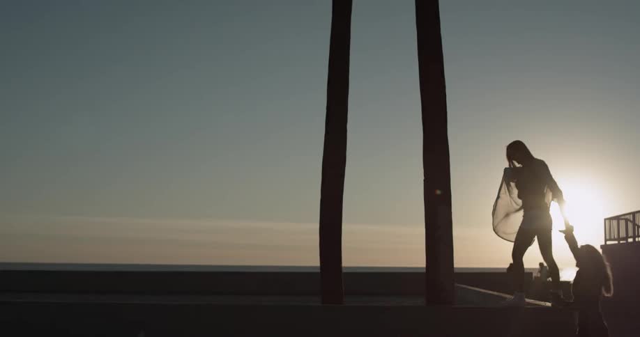 Two women are holding hands in the sunset