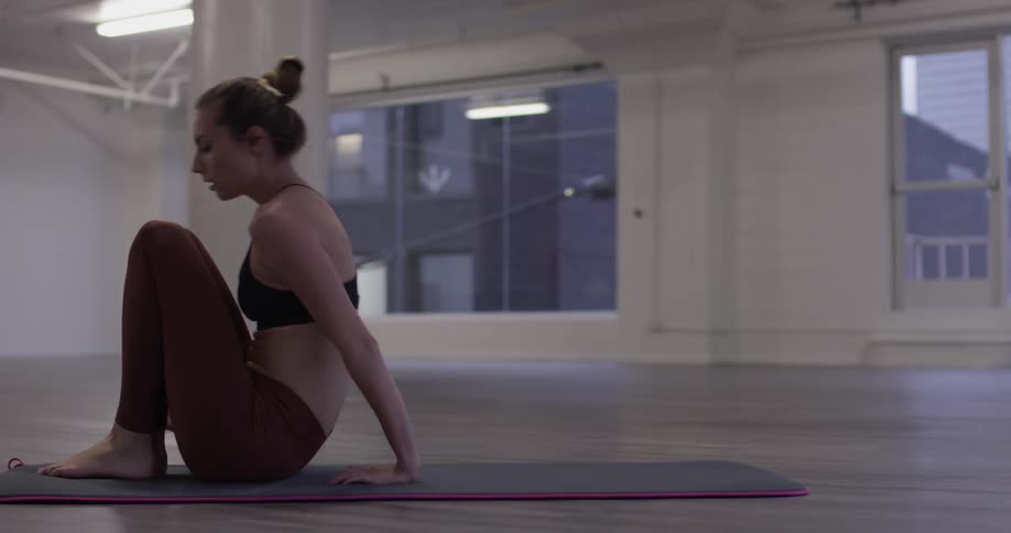 A woman lays with her back to the floor as she does yoga