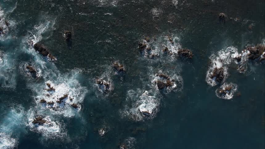 Waves crashing against rocks in the water