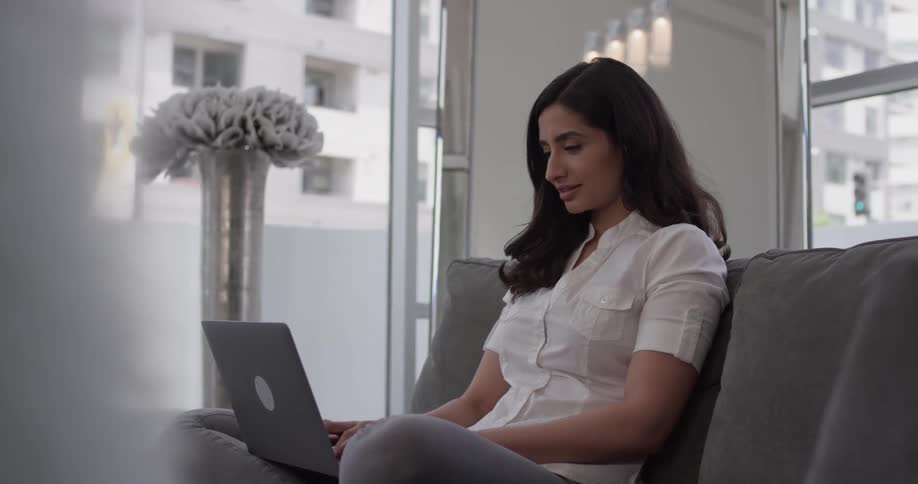 Woman typing on a laptop on the couch