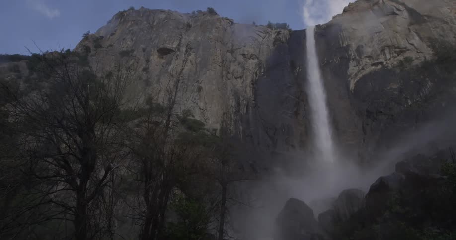 A stream of water falls off of a large cliff