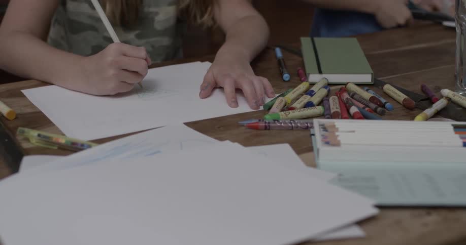 Two children color beside each other