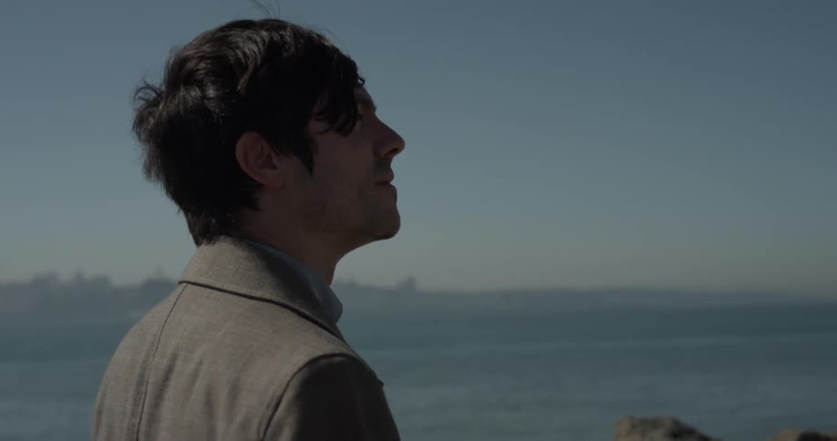Man walks in nature with cityscape in background