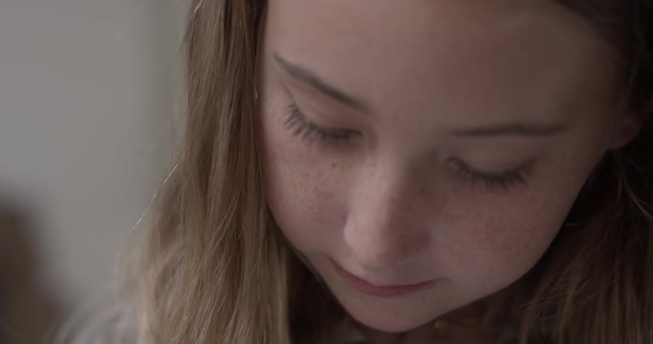 A young girl writing on a piece of paper