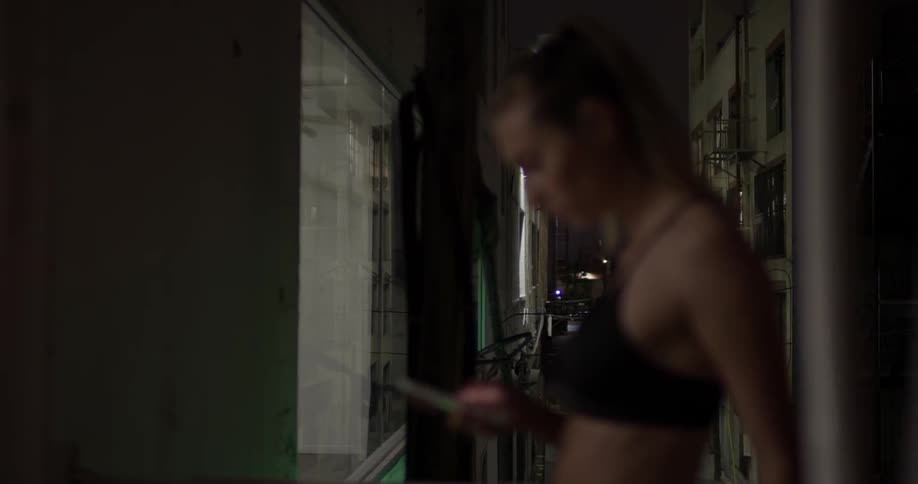 Woman in a sports bra texting on a phone