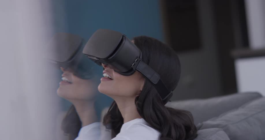 A woman places a virtual reality mask over her eyes