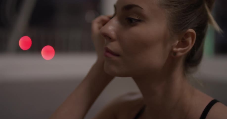 Woman sits rubbing the back of her neck