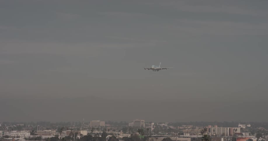 Airplane flies low over city in the fog