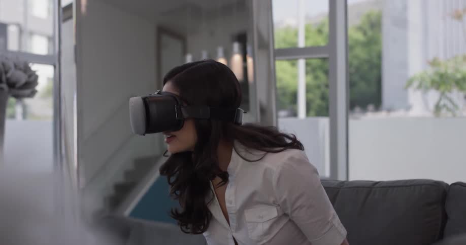 Woman sits on a couch looking through a virtual machine