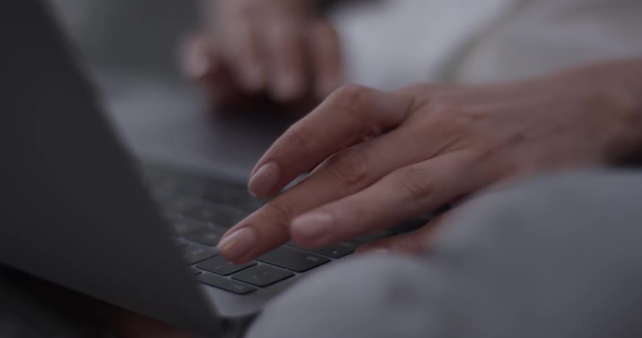 Person sits at a desk typing on a laptop