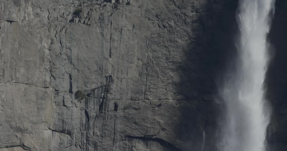 A waterfall plummets down the side of a cliff