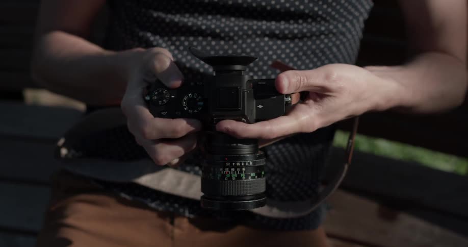 A man using a digital camera to look at photos