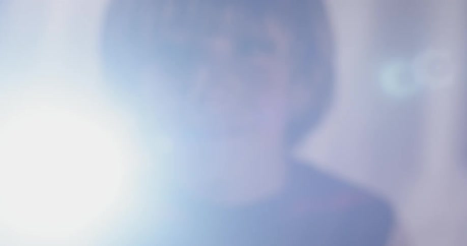 A child shines his light into the camera inside his tent fort he built