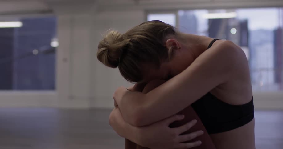 Woman practices yoga in an empty room