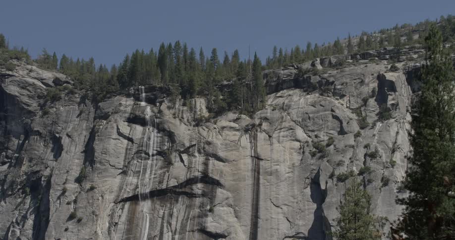 A small amount of water flows down a large cliff