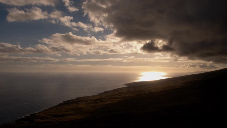 A sun setting at the edge of the ocean