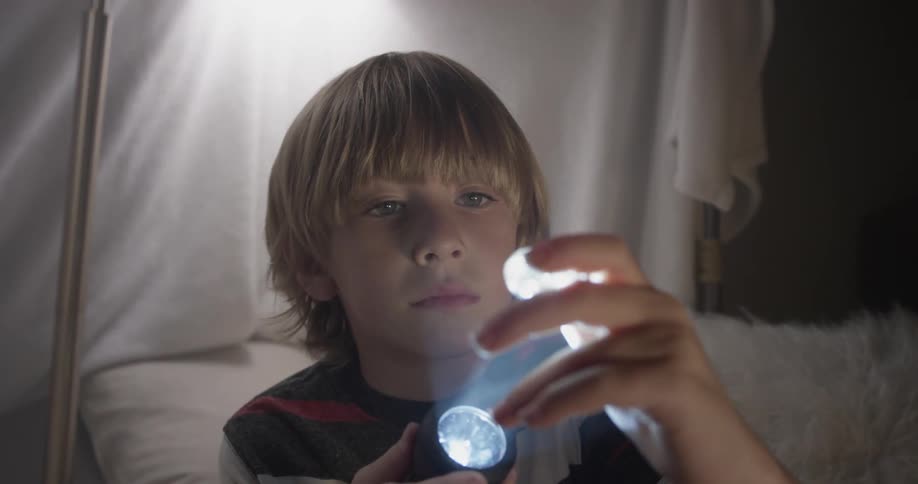 Child plays with plastic toy and flashlight