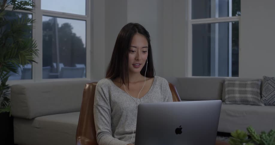 A woman is talking towards the laptop in front of her