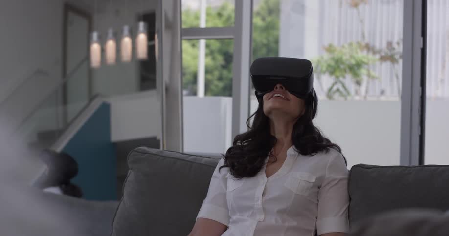 A woman is looking around the room wearing a virtual reality visor